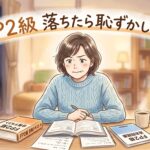 50代の女性が机に向かって勉強しているイラスト。表情は少し悔しそうだけれど前を向いている。テキストと問題集が机の上に広げられている。温かみのある柔らかいトーン。画像の上部に「FP2級 落ちたら恥ずかしい?というテキストが入っている
