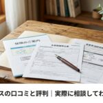 保険の書類とペンが机の上に置かれている、温かみのある自然光の場面。人物は映り込まなくてよい。横長120画像の下部に白い帯を入れて、日本語で『保険マンモスの口コミと評判|実際に相談してわかったこと』とゴシック体の画像